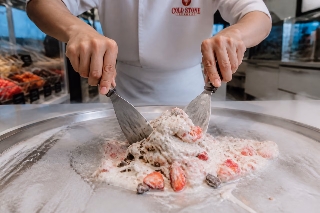 Employee Mixing Custom Ice Cream on a Frozen Granite Slab