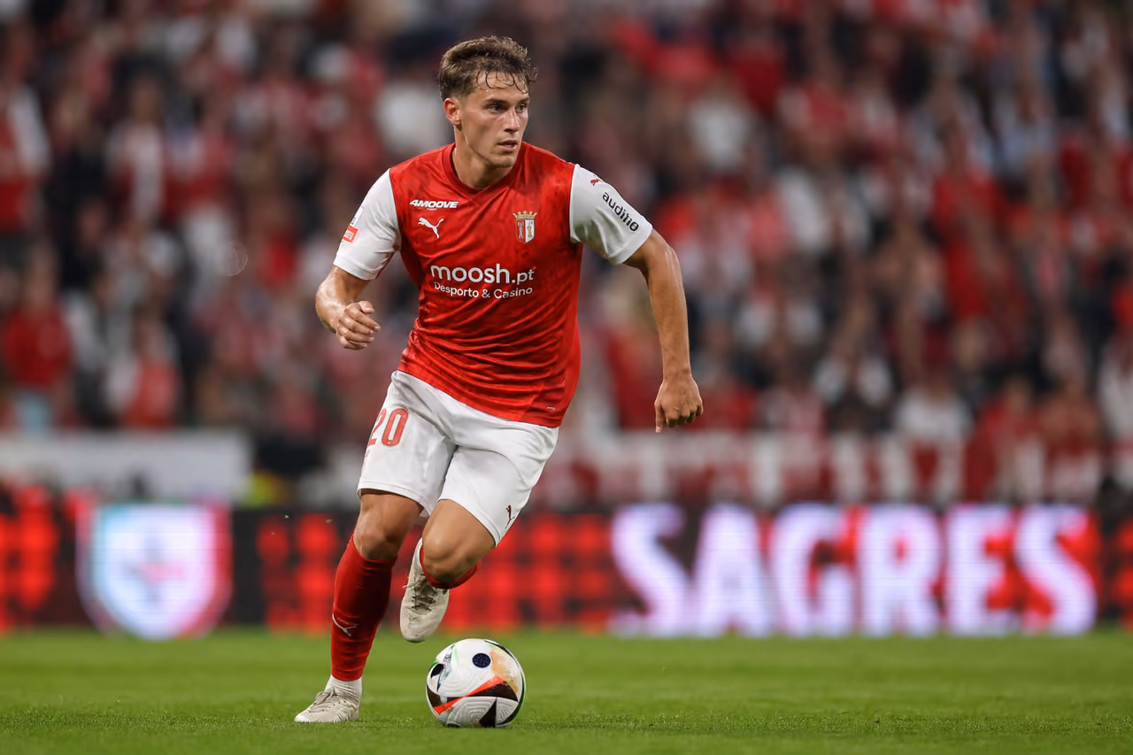 Professional Soccer Player Dribbling Ball on Stadium Pitch