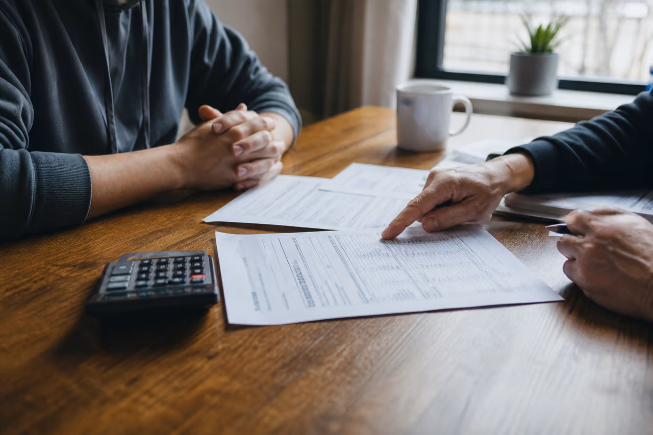 Landlord and Tenant Discussing Rent Increase Over Documents