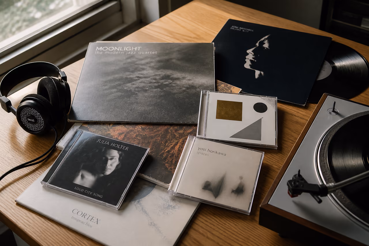 Collection of Vinyl Records and Cds on a Wooden Table