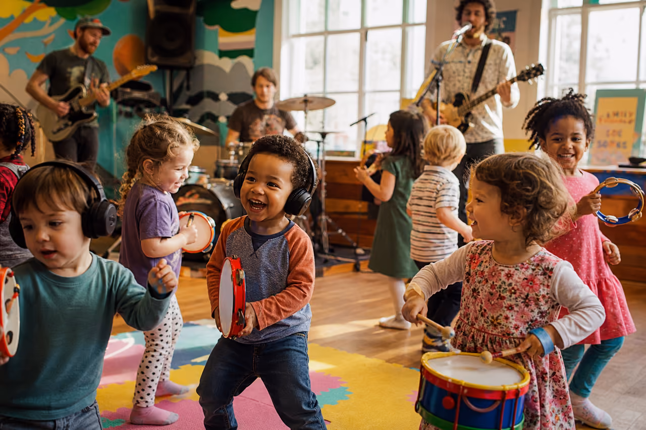 Toddlers Dancing and Playing Instruments at a Community Music Event