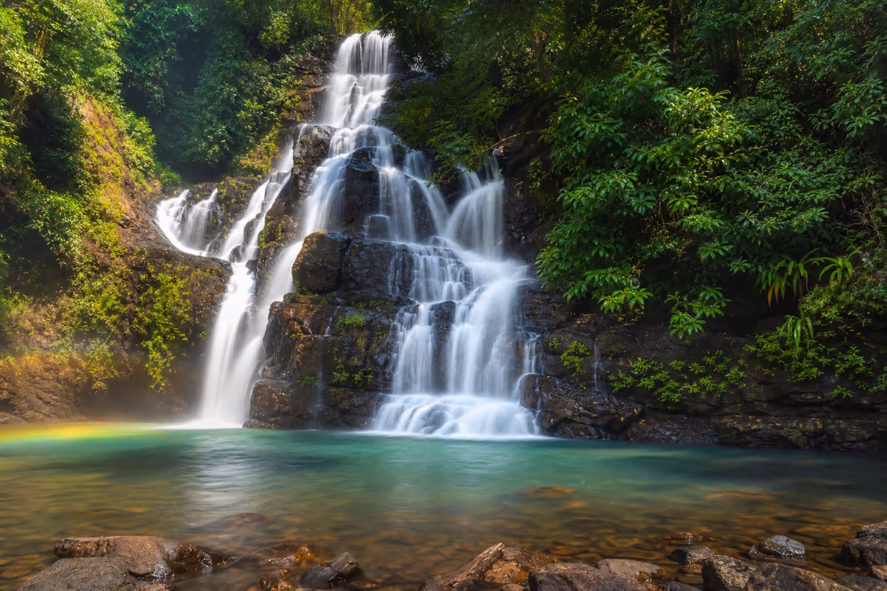 Cascading Arvalem Waterfalls Surrounded by Tropical Jungle in Goa