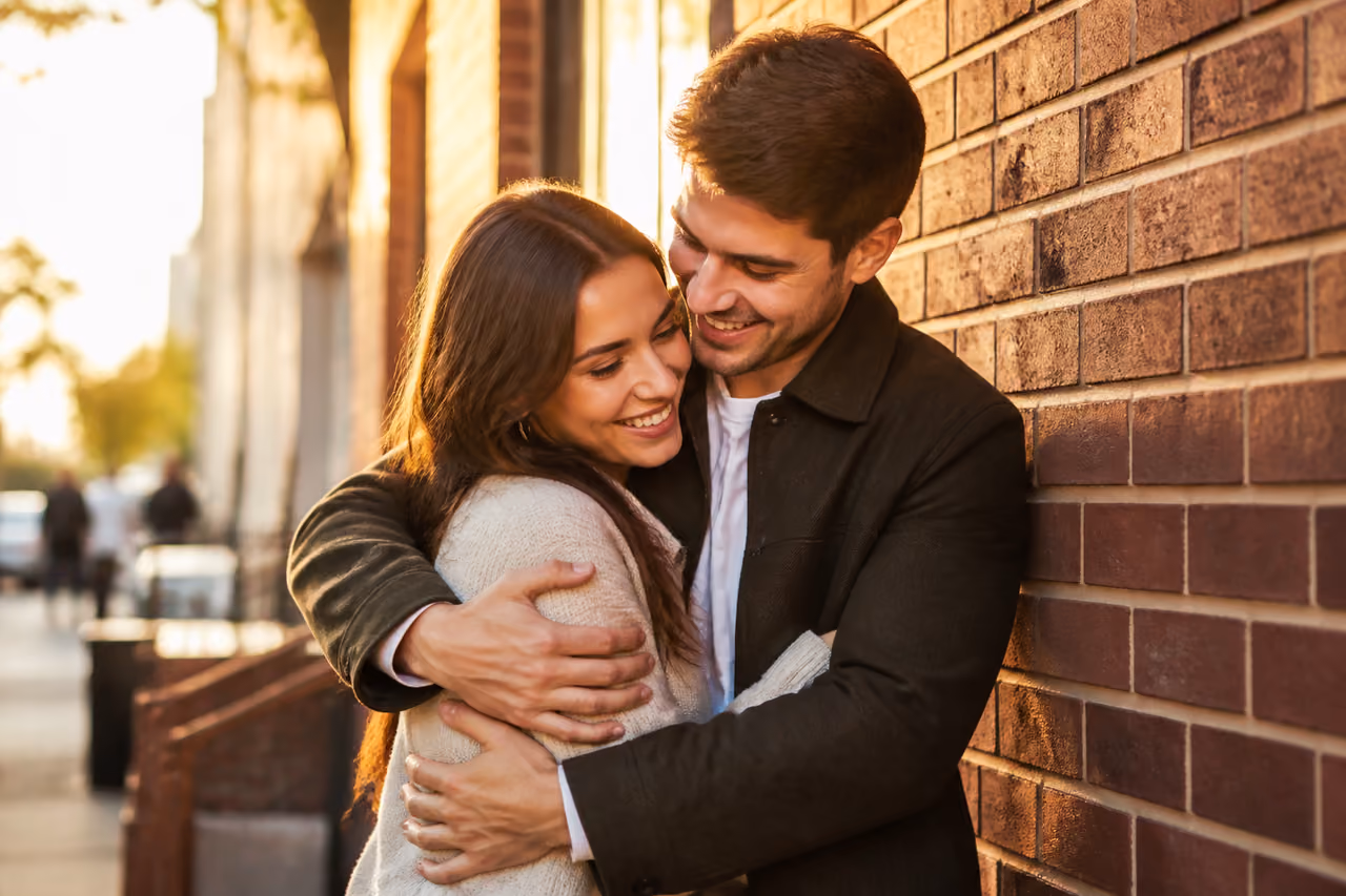 Couple Embracing Passionately Against an Urban Brick Wall