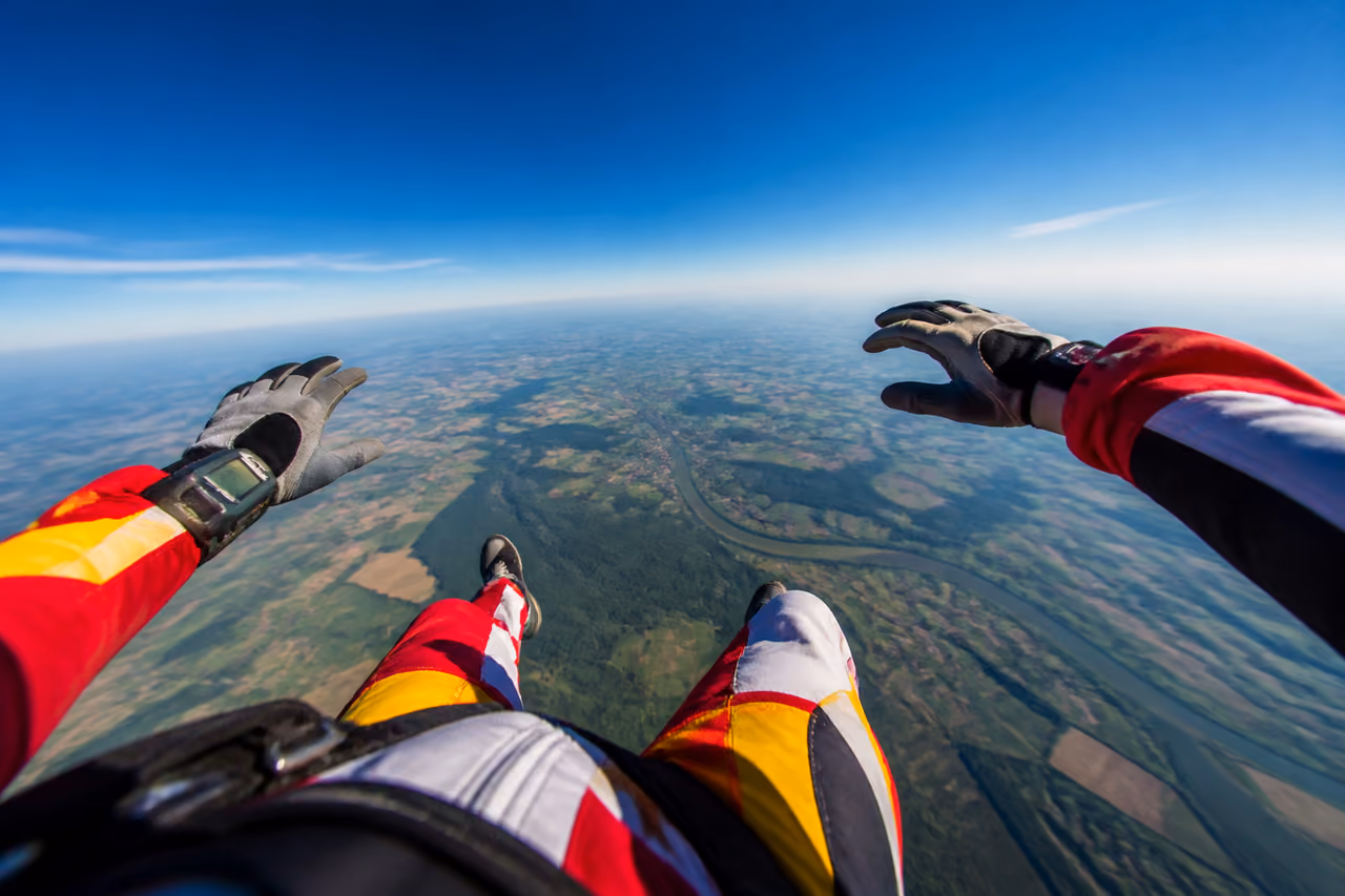 Skydiver in Freefall Over Rural Landscape
