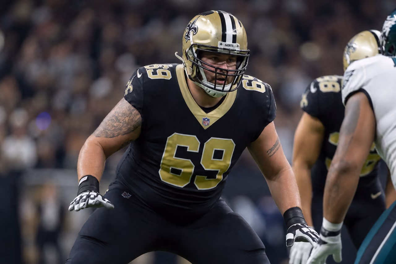 Football Player Wearing Number 69 Jersey on Stadium Field