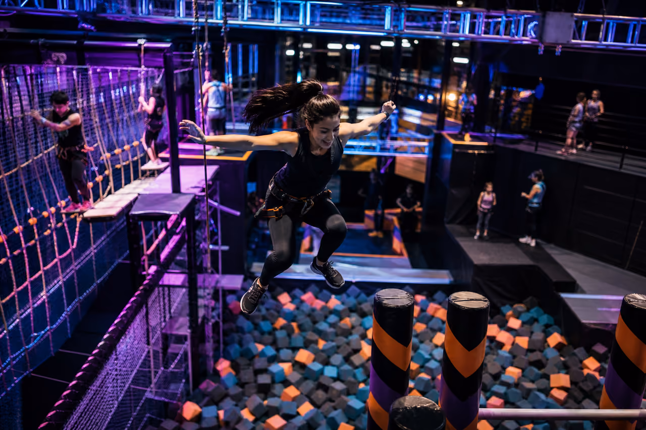 People Navigating a High Ropes Course at an Indoor Adventure Park