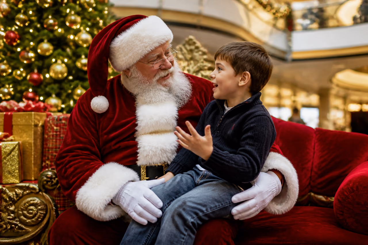 Child Visiting Santa Claus in a Decorated Mall Grotto