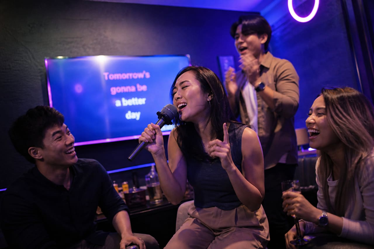 Group of Friends Singing Together at a Karaoke Party