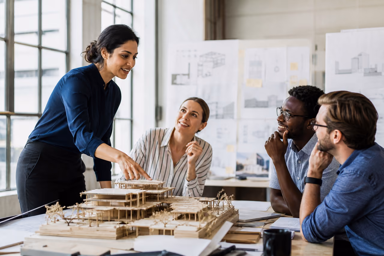 Professional Architect Presenting a Model to Colleagues in Studio