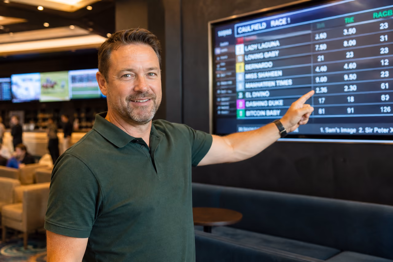 Man Presenting Sports Betting Odds in a Modern Lounge