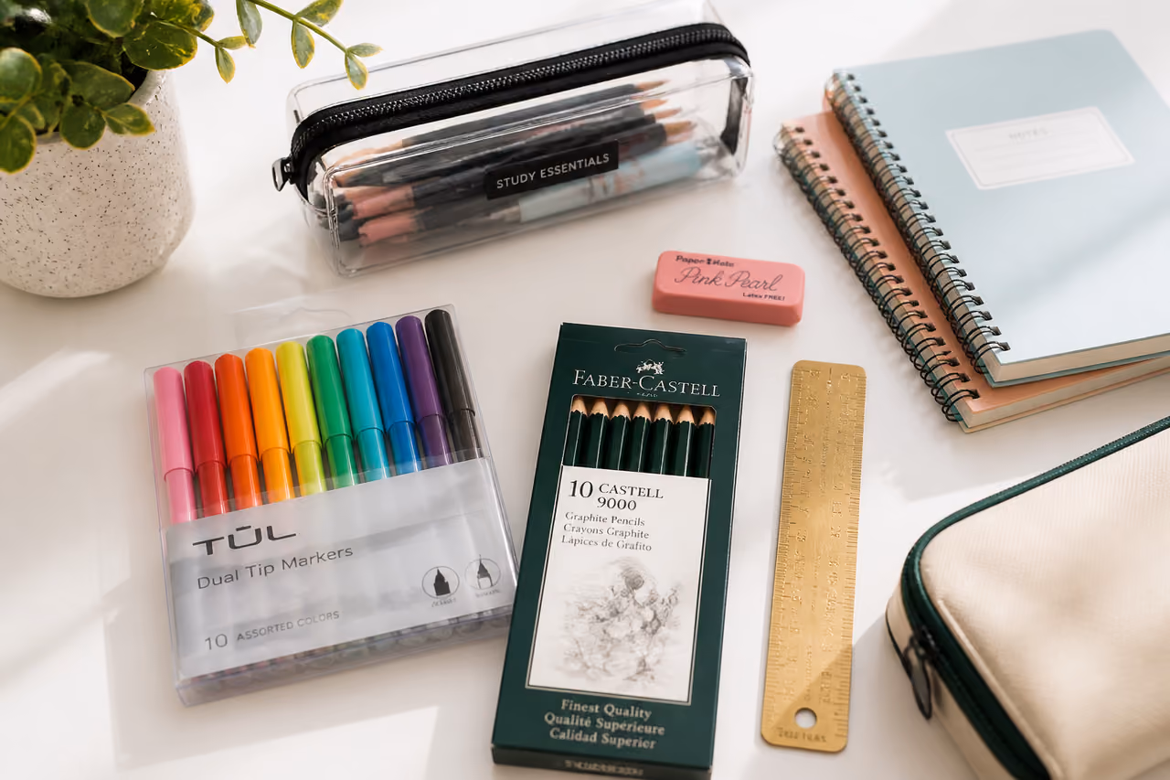 Assorted Colorful School Supplies Arranged on a White Desk