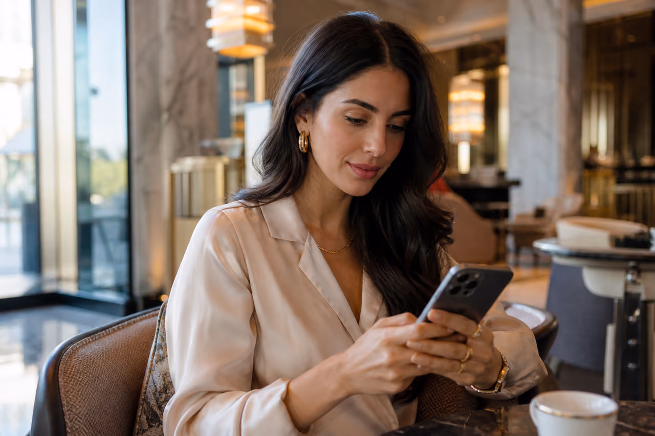 Elegant Woman Using Smartphone in Luxury Hotel Lounge