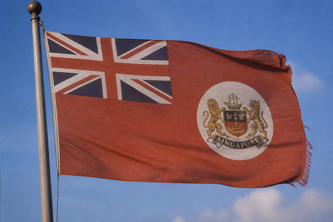 Vintage Singapore Colonial Flag Waving Against Blue Sky
