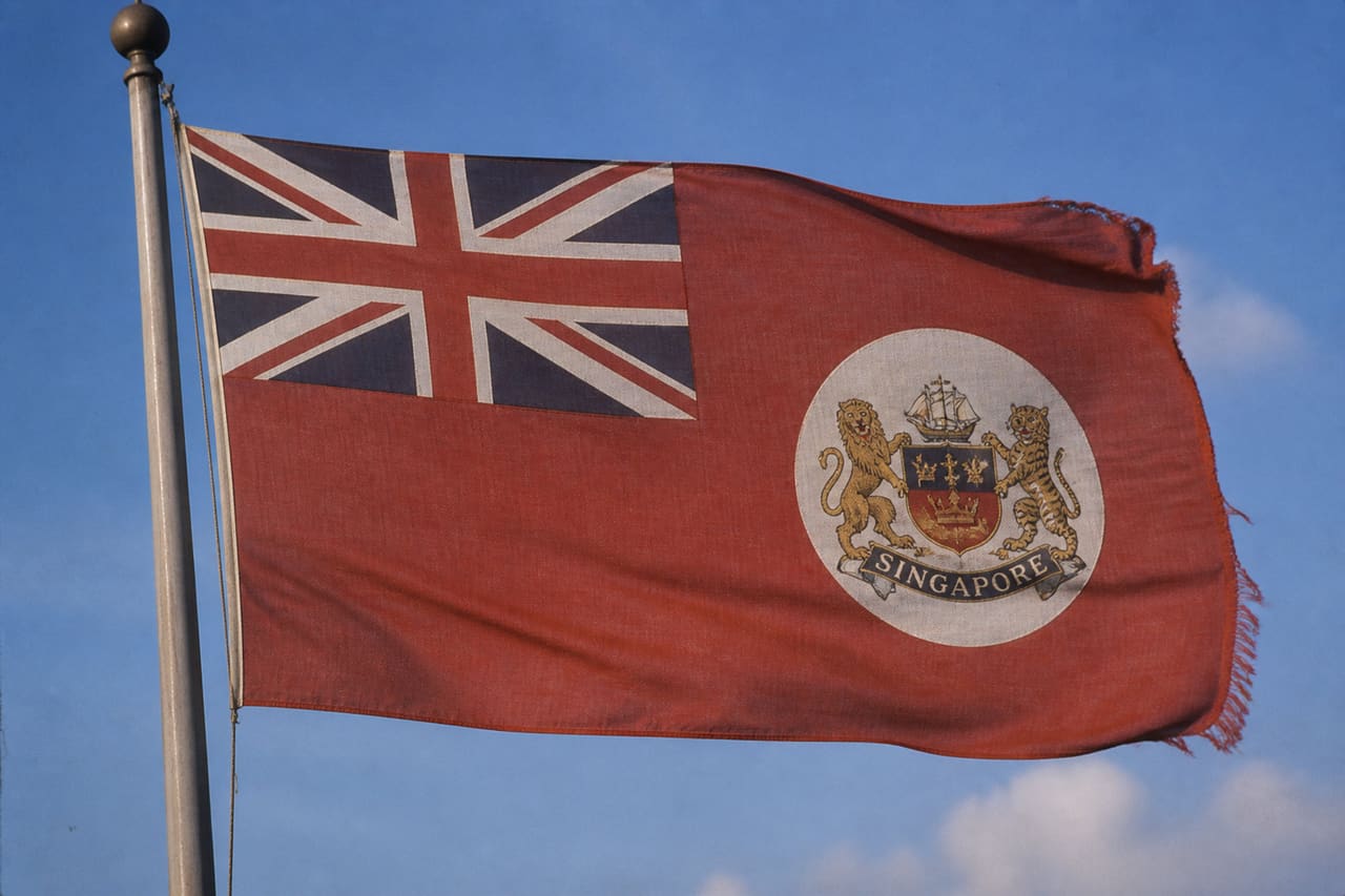 Vintage Singapore Colonial Flag Waving Against Blue Sky