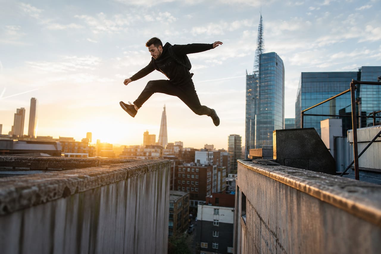Parkour Athlete Jumping Between Buildings in Modern City