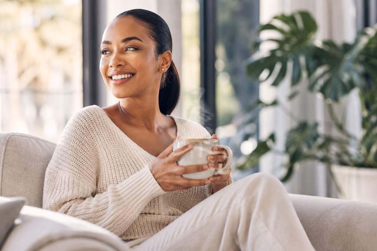 Woman Enjoying Morning Tea in a Sunlit Modern Living Room